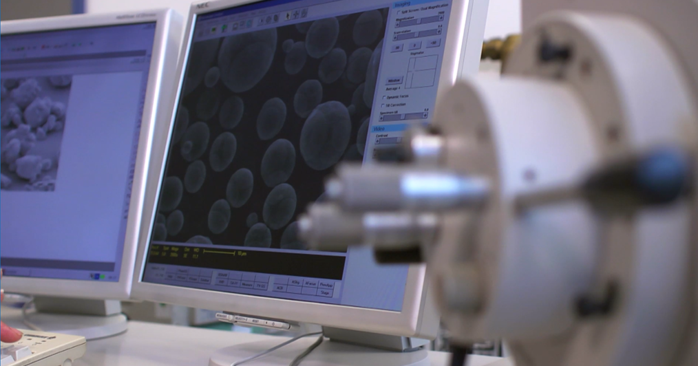 Quality control lab monitor showing microscopic material analysis results